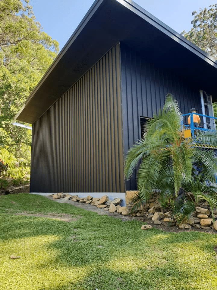 Dark barn-style shed with garden